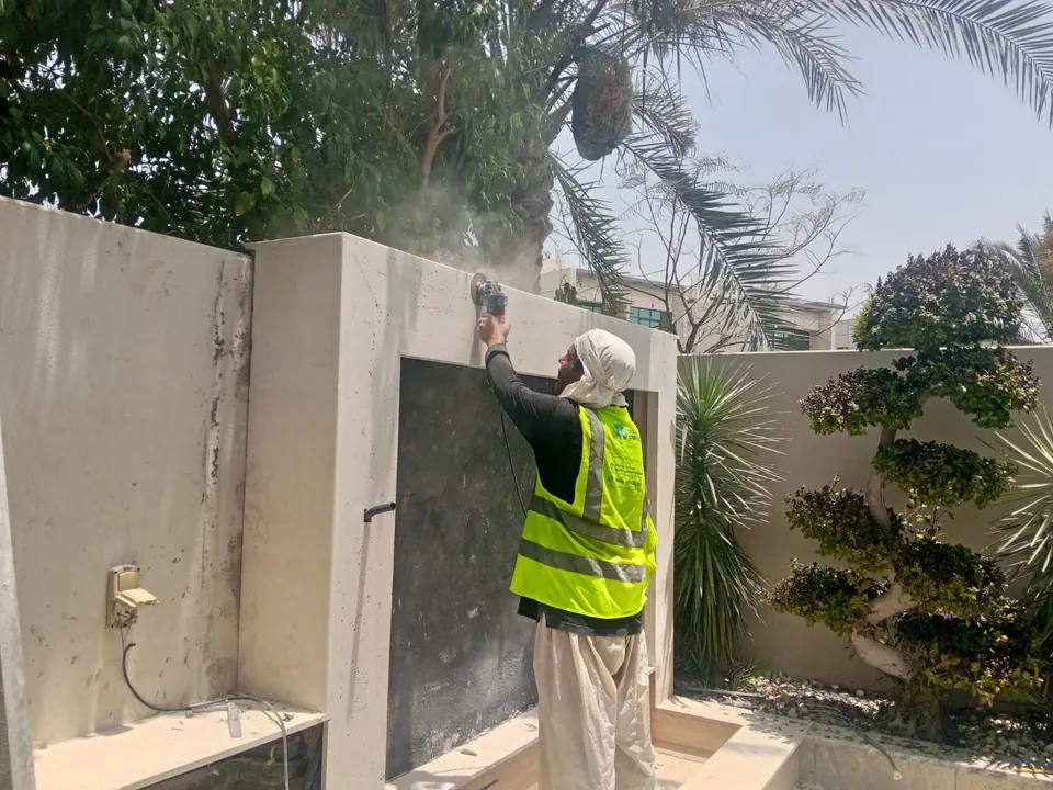 Technician pressure-washing an exterior boundary wall