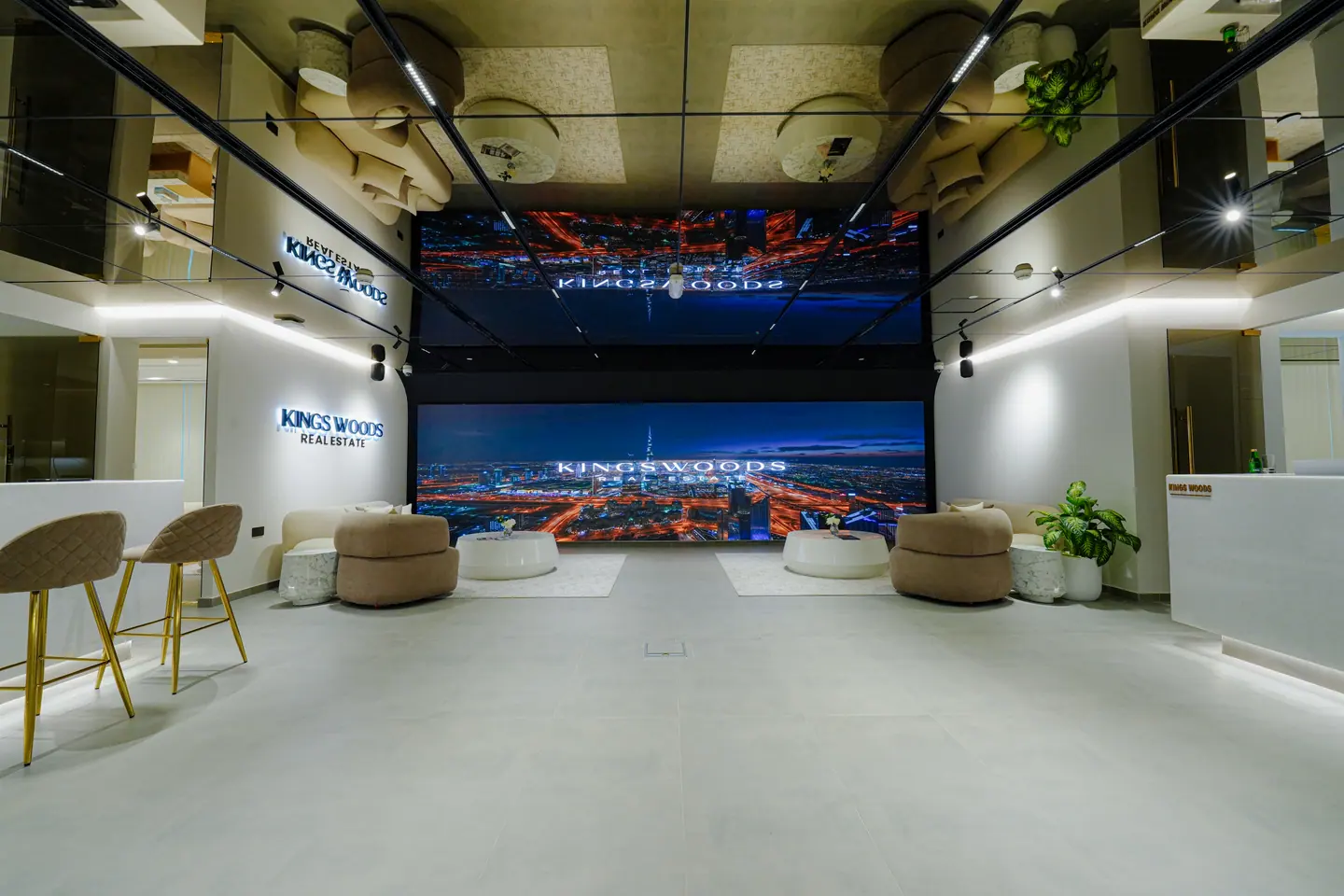 Client lounge with a full-height LED video wall, upholstered seating and feature lighting — Kings Woods Real Estate office fit-out by Urban Crown, Dubai