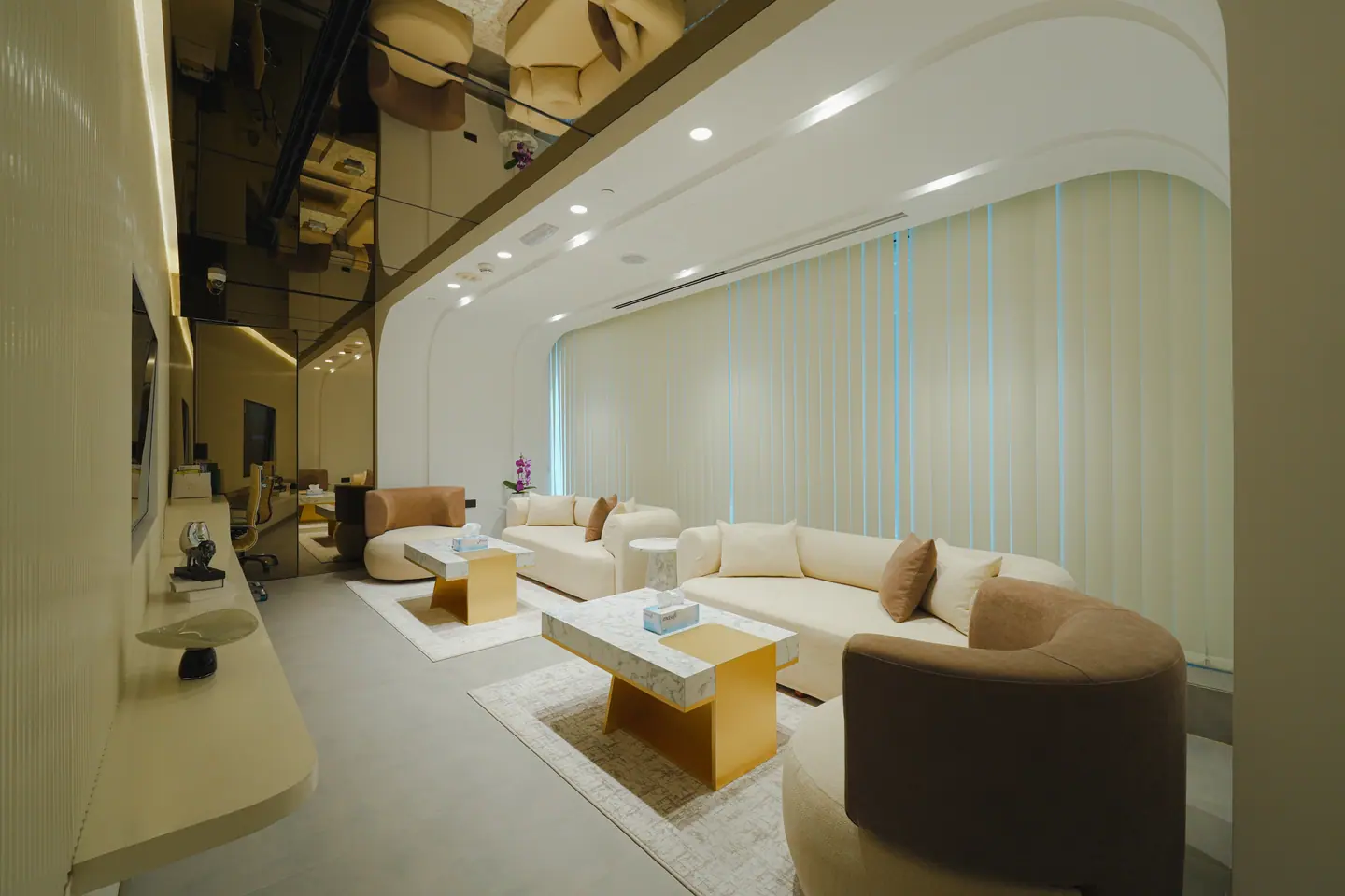 Executive lounge with a sculptural suspended ceiling, bouclé sofas and marble-and-brass coffee tables — Kings Woods Real Estate office fit-out by Urban Crown, Dubai